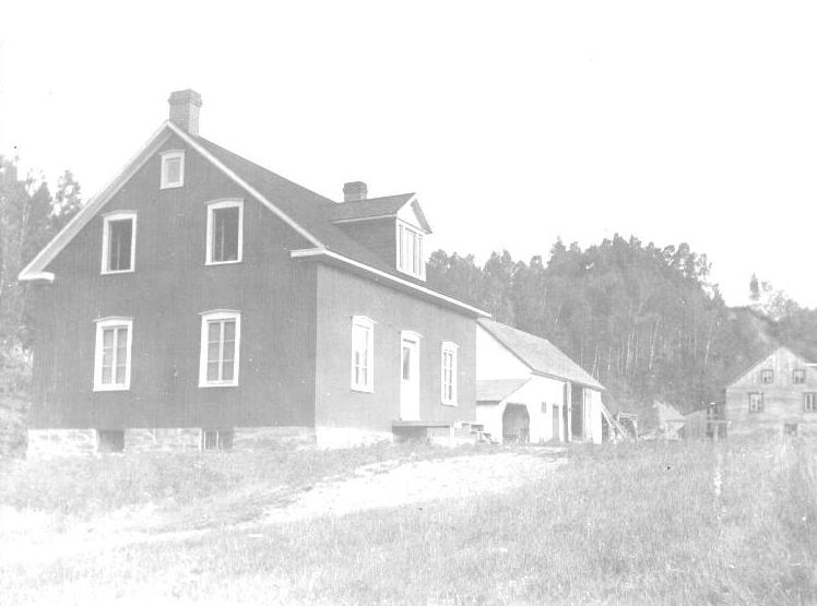 En avant plan, la maison des Thibodeau et derrière la grange et le moulin. Photo: Archive familliales Thibodeau