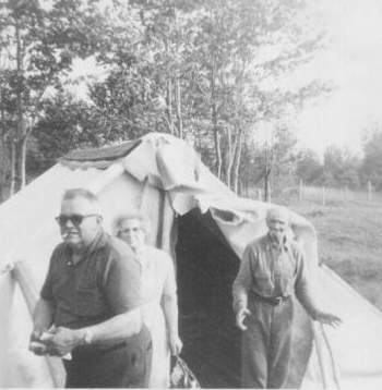 Tente de toile ayant servi d'habitation temporaire à Omer sur ses terres du lot 869. Omer se trouve devant l'entrée de la tente. Source: Archives familliales Thibodeau (Édouard)